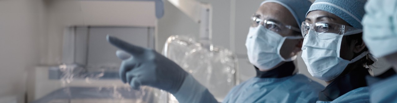 Physicians in operating room looking at a screen.