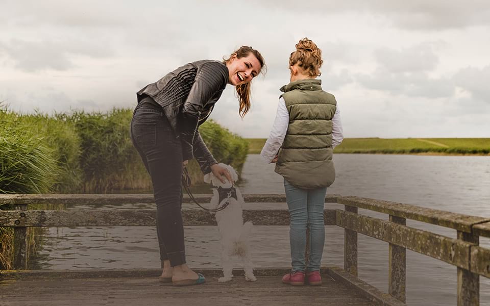 Mother and her daughter walking their dog on the dock