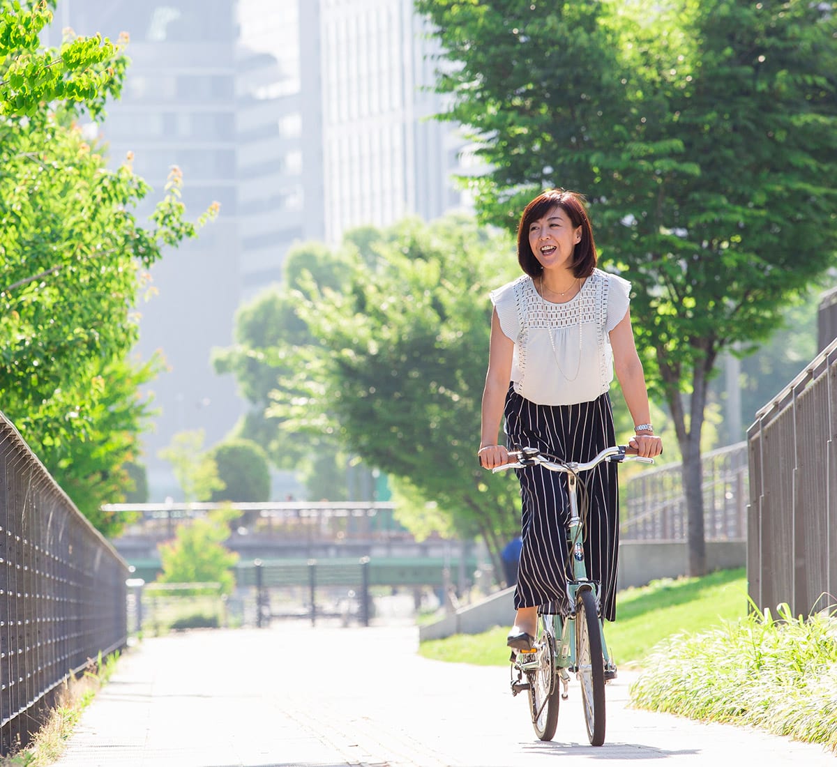 A woman riding her bicycle through a city park