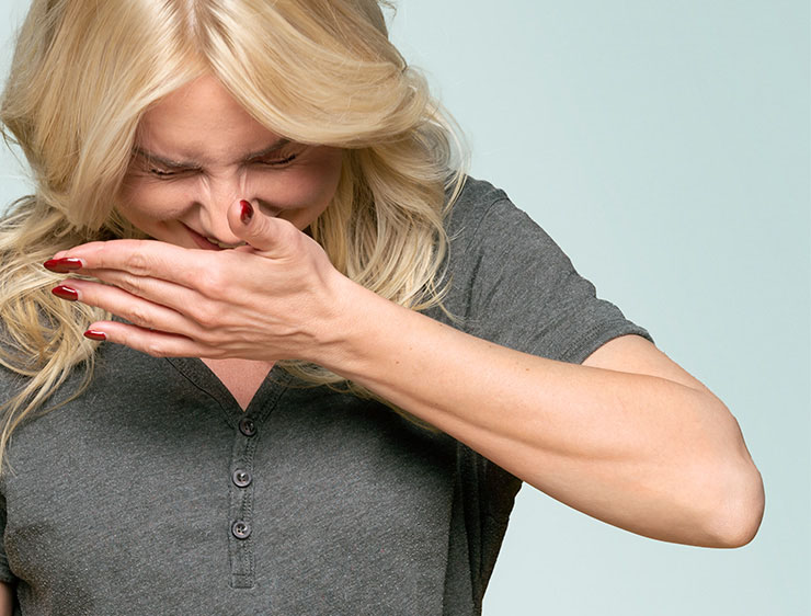 Woman covering a sneeze.