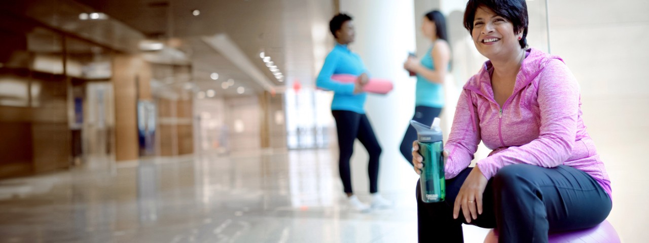 Three women in a hallway after a fitness class.